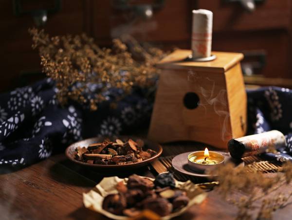 ambiente com fumaça de incenso, vela e outros item da medicina tradicional chinesa